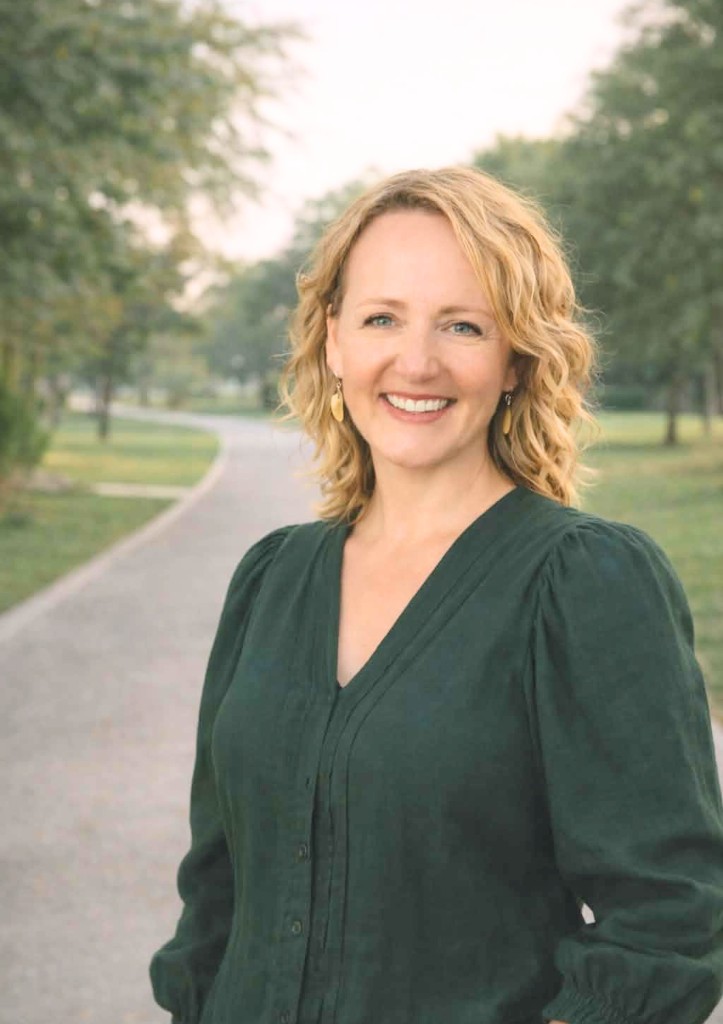 Professional portrait of Leigh Spencer, founder of Tides of Knowing, smiling outdoors in a park setting.