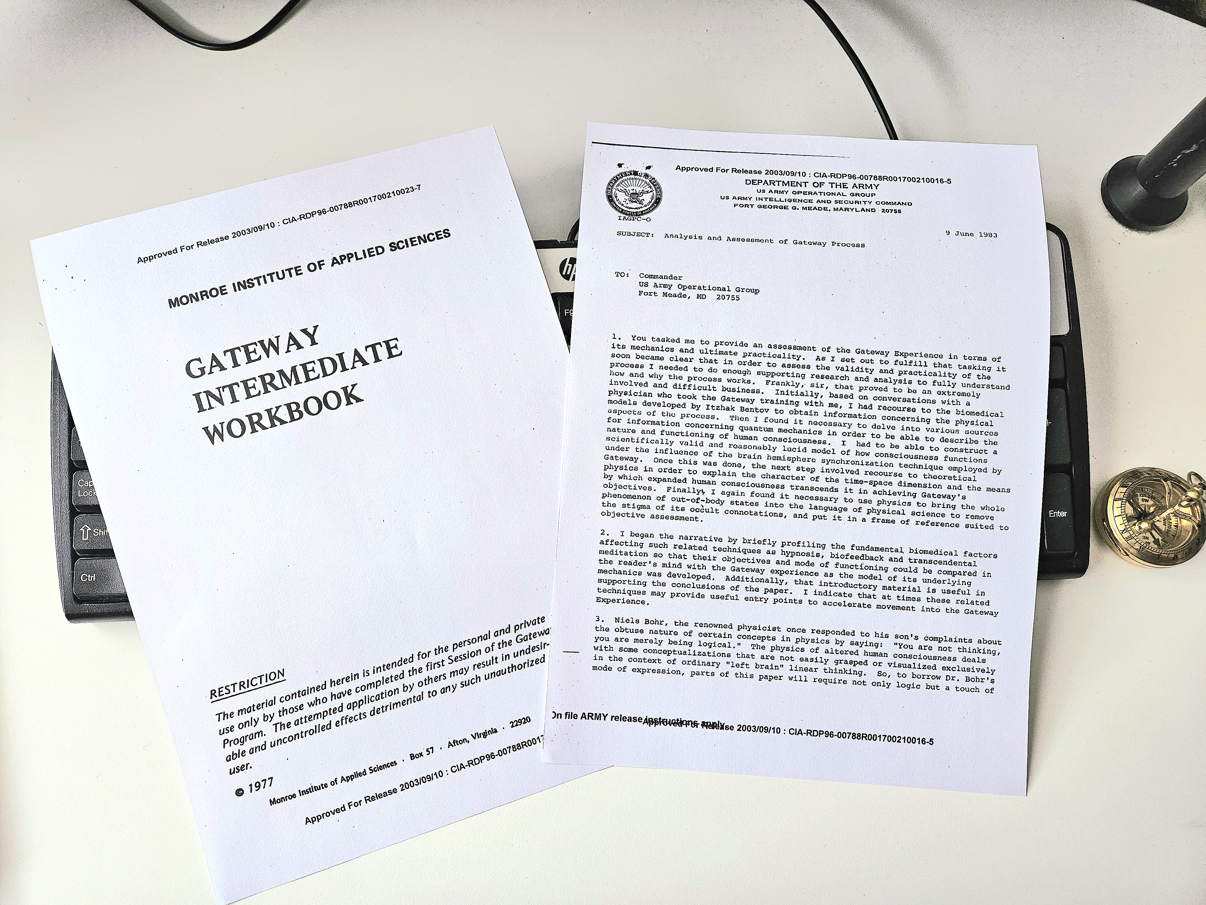 Declassified Gateway Process and remote viewing research documents on desk beside keyboard